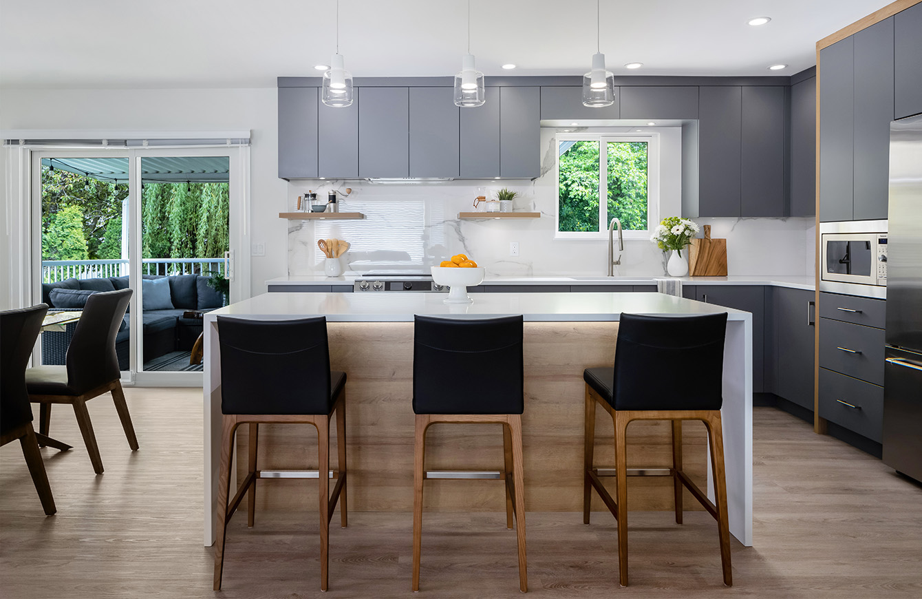 Image of a contemporary kitchen featuring a sizable island and stylish black stools.