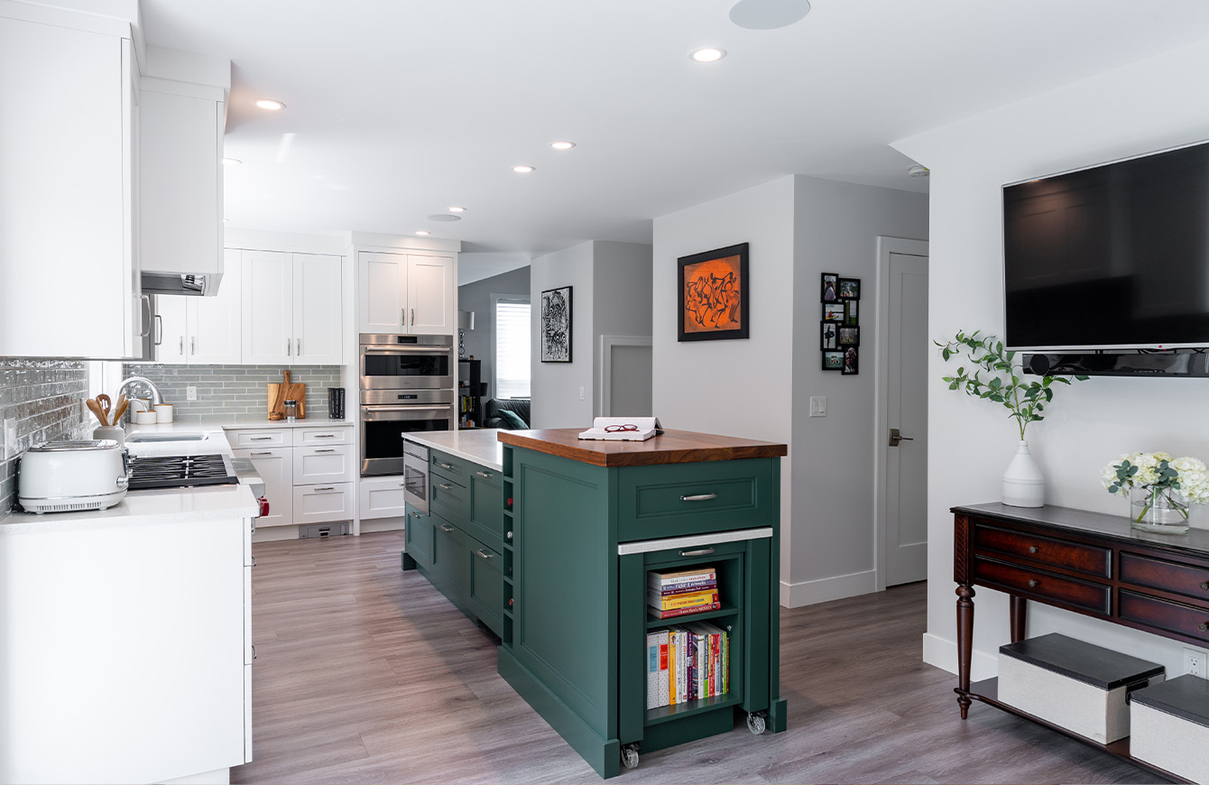 Modern kitchen featuring green island and TV.