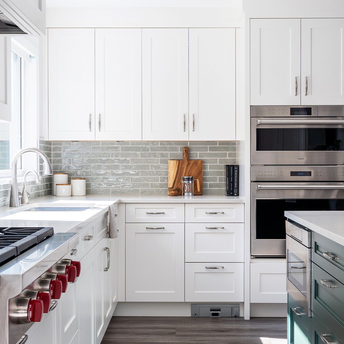 Sleek kitchen design featuring white cabinets and stainless steel oven.