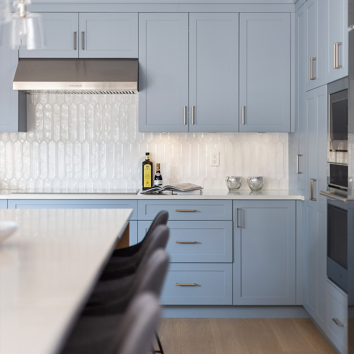 A kitchen with blue cabinets and a white counter top.

