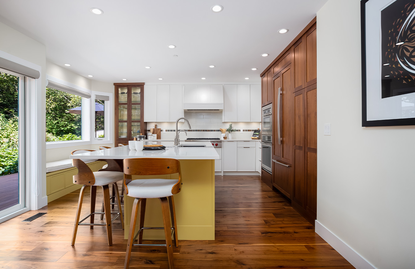 A spacious kitchen with a big island and a window bringing in natural light.