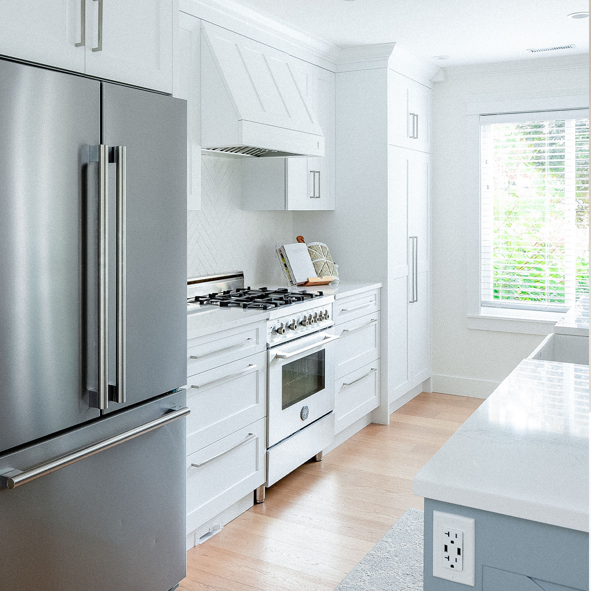A modern kitchen with stainless steel refrigerator and stove.