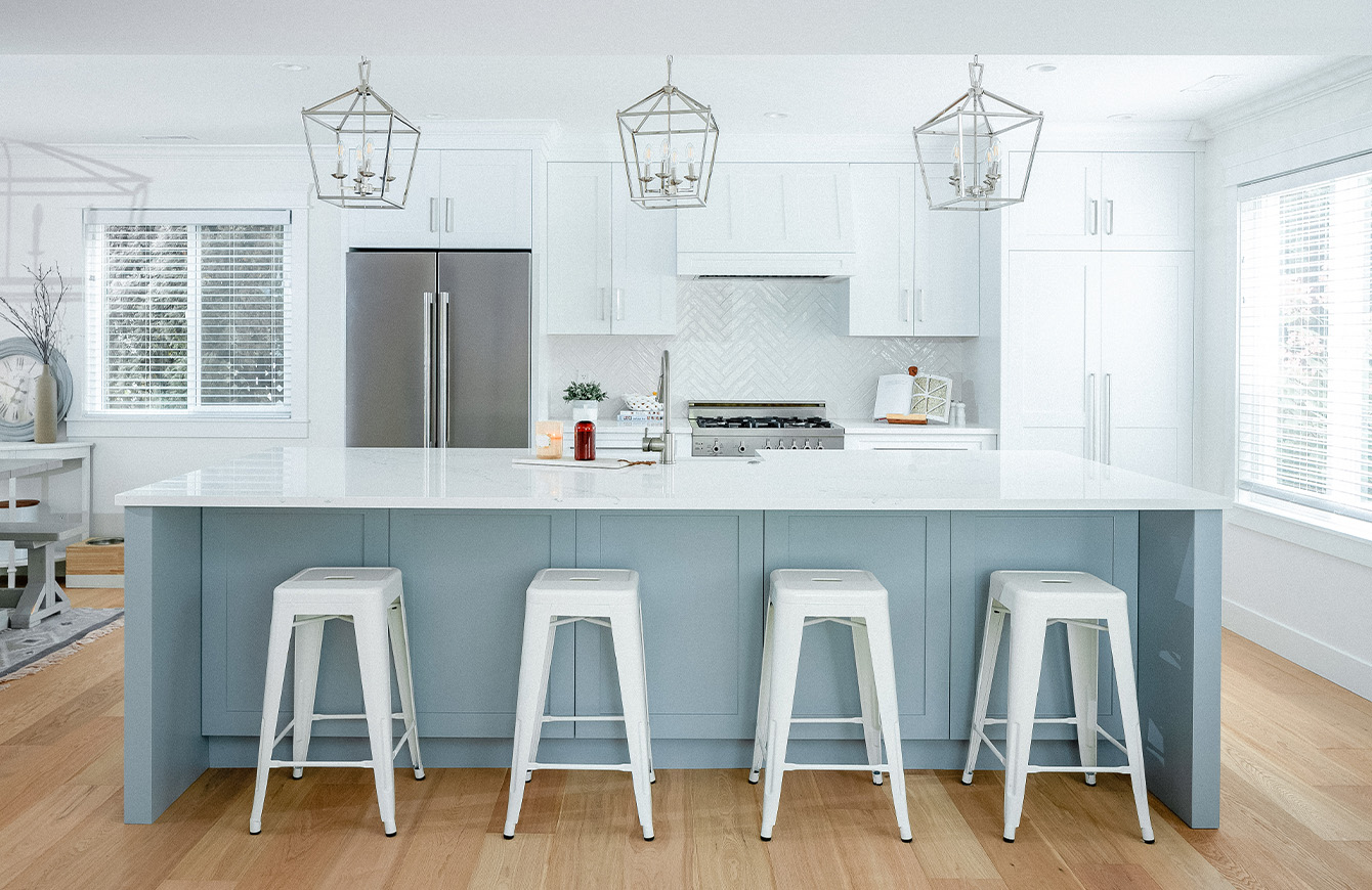 Modern kitchen with white cabinets and stools, creating a clean and sleek look.