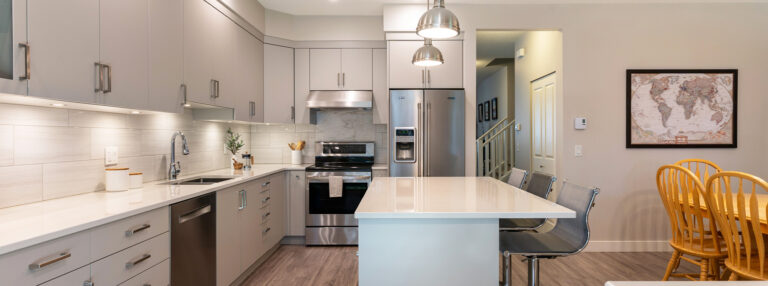 A kitchen with a white counter top and a table.