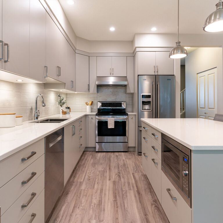 A modern kitchen with sleek stainless steel appliances and a spacious island for cooking and gathering.