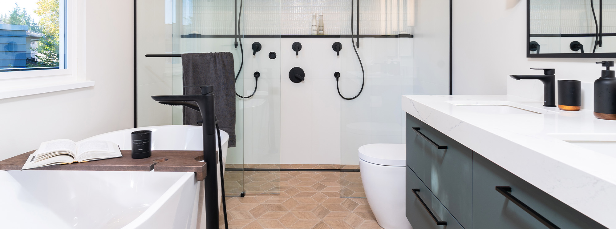 A modern bathroom with a shower, sink, and toilet.