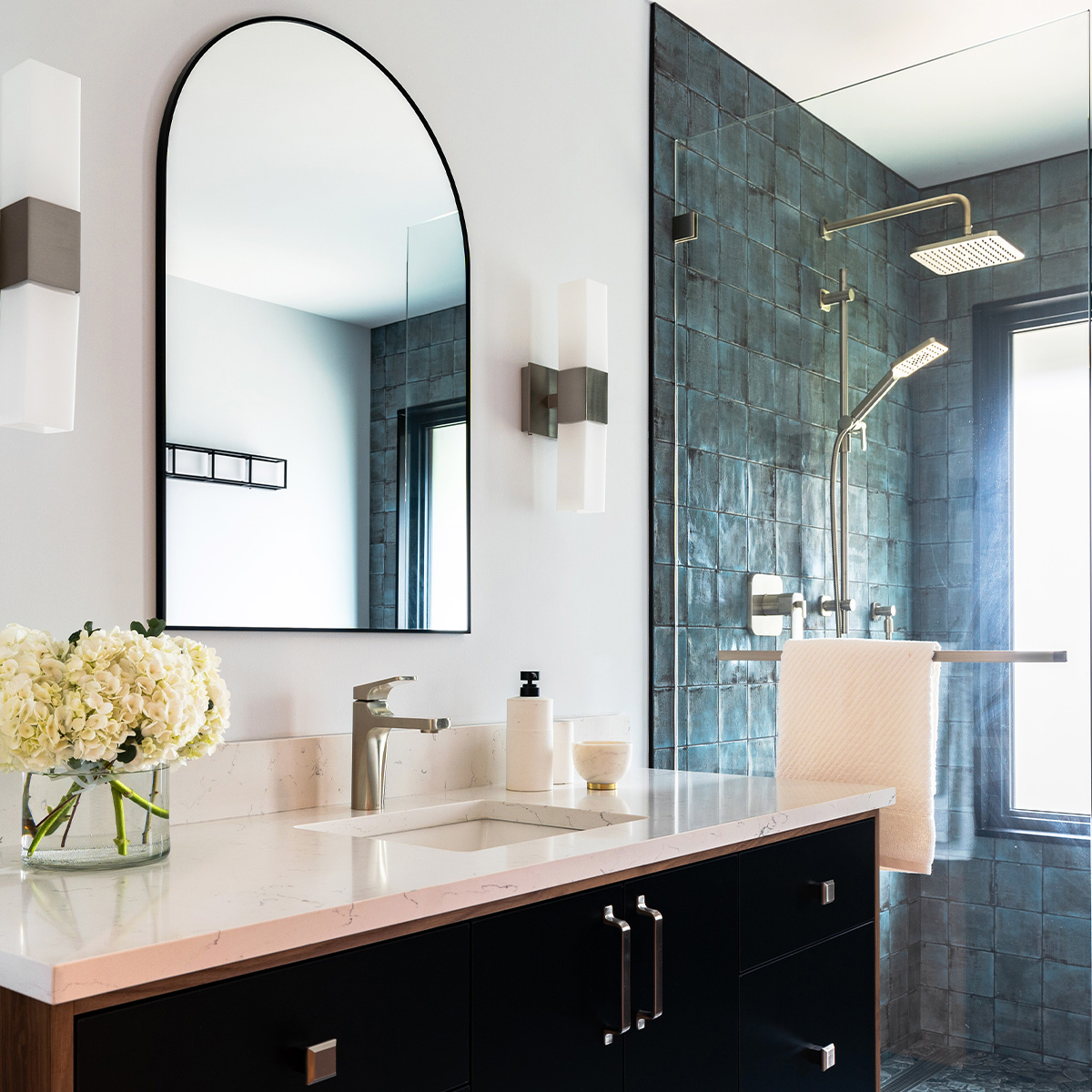 Modern bathroom featuring large mirror and shower.