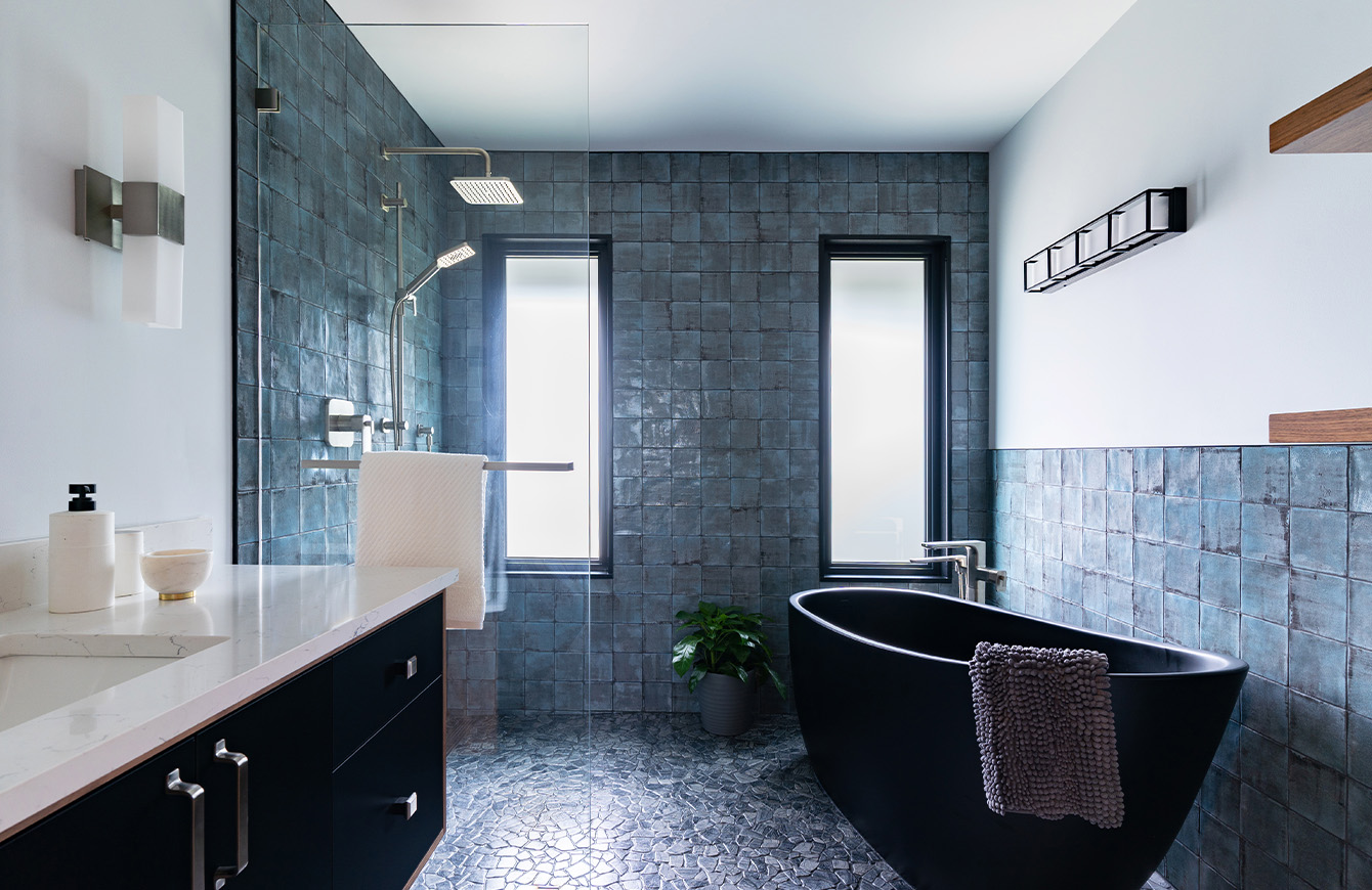 A sleek bathroom with a black tub and a sink.