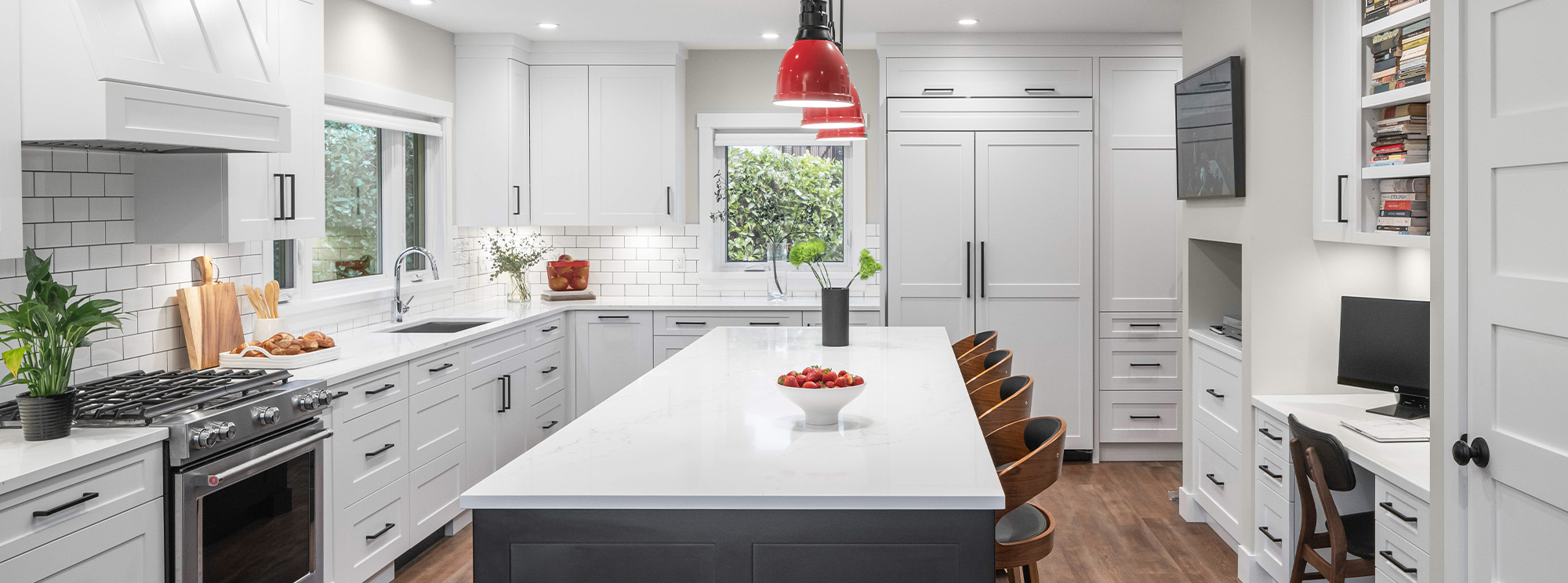 Modern kitchen featuring white cabinets and a vibrant red pendant light.