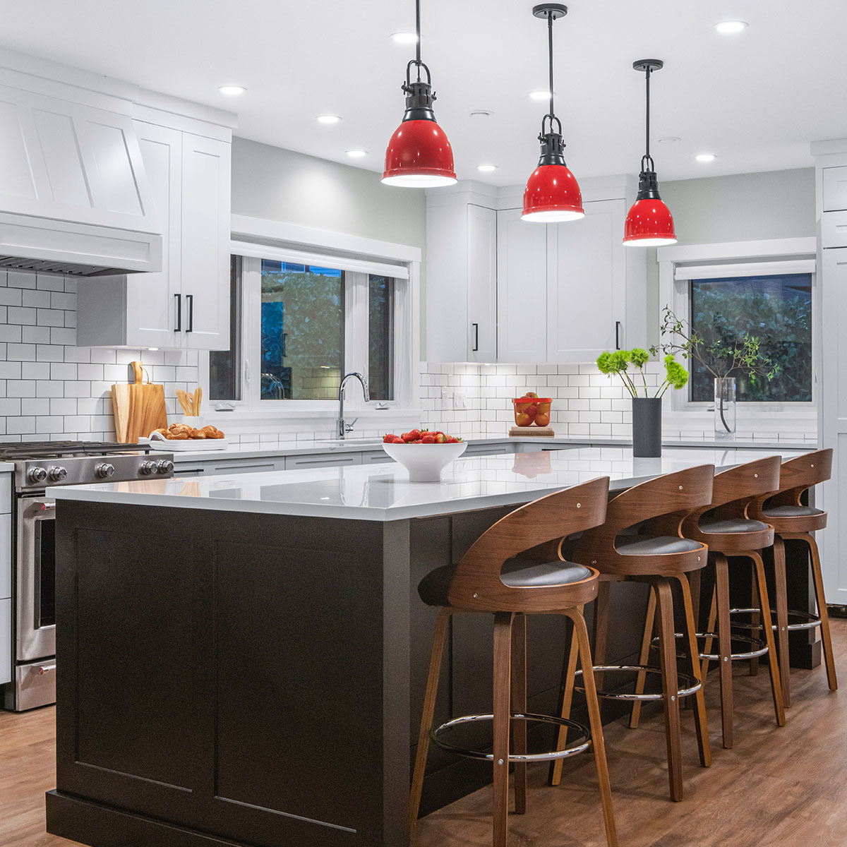 Modern kitchen with center island and red pendant lights.