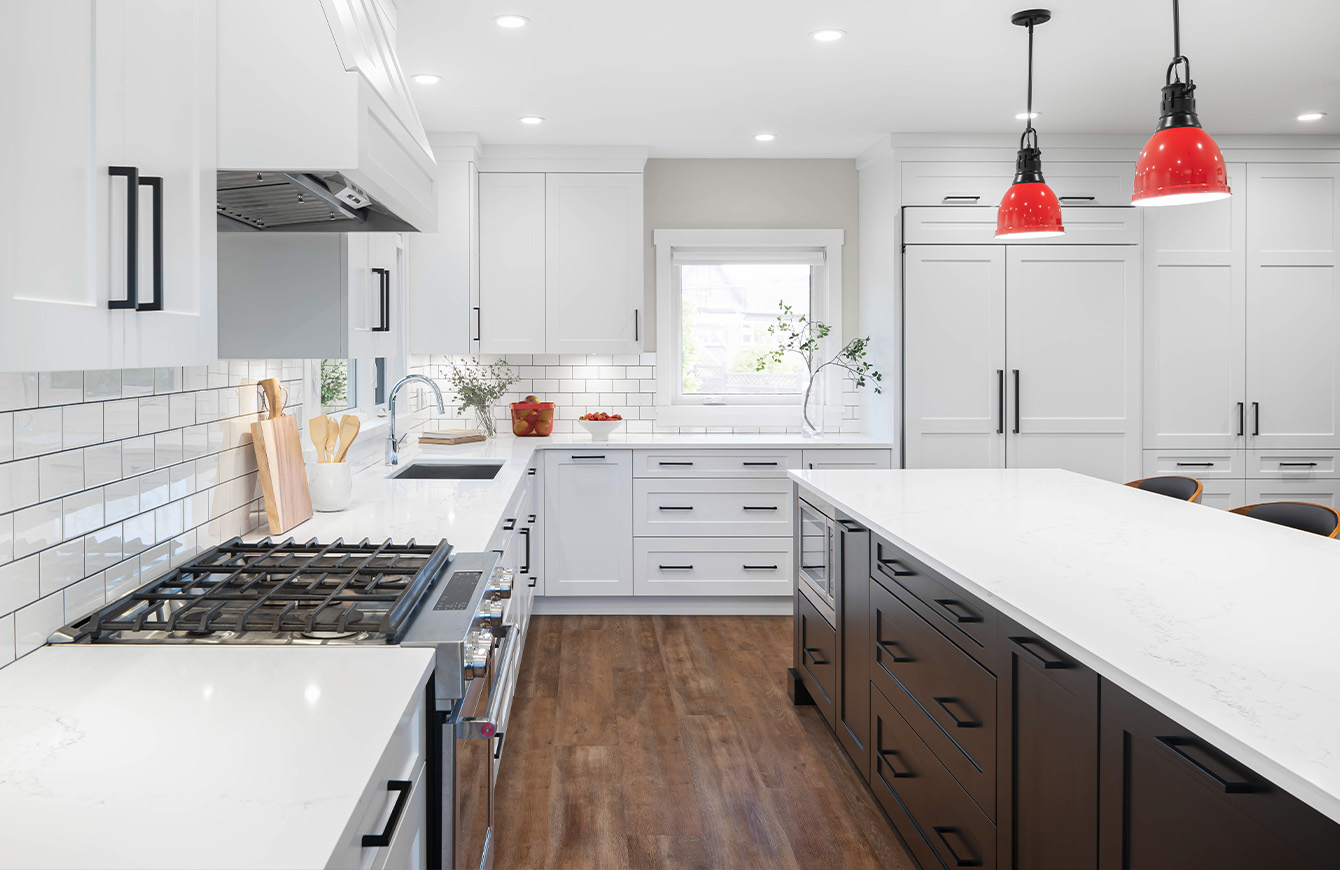 Modern kitchen with white cabinets and sleek black appliances.